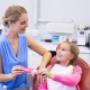 Smiling-mother-giving-tooth-brushing