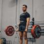 Personal training client Tino executing a deadlift during his strength training session in the gym.
