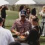 Outdoor canapé service, staff serving arancini to guests in a field