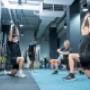 Two men working with the personal trainer, stretching after a great training session