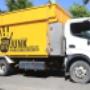 a-yellow-and-white-goodbye-junk-truck-parked-on-the-side-of-a-road