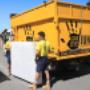 goodbye-junk-worker-carrying-a-bed-next-to-their-yellow-truck