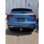 Blue Jaguar E‑PACE rear with tow hitch and “#TOWBARJOE” plate in a car park.