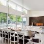 Dinning_area_with_glass_fire_place_on_and_large_bright_seating_area_with_court_yard_visible_through_