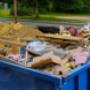Blue construction debris container filled with rock and concrete rubble