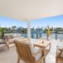 Covered waterfront patio with outdoor lounge seating and marina views