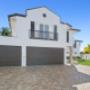 Backyard pool area with timber deck, sun loungers, and canal outlook