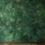 A deep forest green Venetian plaster wall with a smooth surface intricate swirling patterns that res