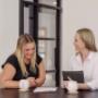 Two Trekk Gympie advisors sit together in a relaxed, light-filled meeting space, reviewing documents and sharing a laugh. A genuine moment of connection that reflects the firm’s personable approach to client advice.