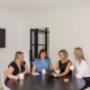 The Trekk Gympie team collaborates in a team meeting around a circular table with coffee mugs and tablets. The space is open and light-filled, creating an atmosphere of open communication and teamwork.