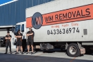 WM Removals truck with three professional removalists posing beside ready for removal services