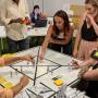 A collaborative stakeholder mapping workshop with participants using diagrams, cutouts, and sticky notes to identify and organize relationships. A hands-on approach to visually mapping stakeholder interactions and roles.
