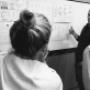 A collaborative design workshop with team members reviewing wireframes and discussing user flow ideas on a whiteboard. The session focuses on refining concepts and aligning on design objectives for an engaging user experience.