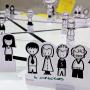Close-up of stakeholder mapping tools with paper cutouts labeled "6 Directors," arranged on a table. A visual representation of roles and interactions during a collaborative workshop.