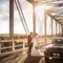 Bride and Groom on bridge in the sunset with mustang next to them photographed by Thierry Boudan Photography
