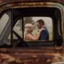 Riverwood downs Bride and Groom kissing in the rain framed by rustic car during there wedding day by Thierry Boudan Photography