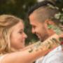 Bride and Groom smiling at each other with long glass vices in the background by Thierry Boudan Photography