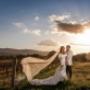 Bride and Groom smile whilst having wedding photo taken with the unseating behind them at Peterson house wedding venue by Thierry Boudan Photography