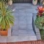 Wide tiled stairs descending to a lower courtyard with modern planters