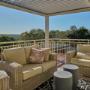 Outdoor lounge on covered deck with wicker sofas and scenic outlook