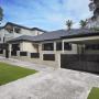 Renovated home exterior with charcoal roof, modern fence, and black window frames