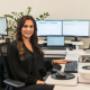 A business advisor at Trekk Advisory Northern Rivers is seated at her workstation with multiple monitors, focused yet approachable. The setup shows the detail-driven side of accounting and advisory work.