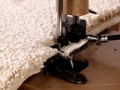 cream carpet is being overlocked with sewing machine