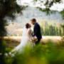 Bride and groom embracing in a beautiful outdoor setting, capturing a cinematic wedding moment with natural scenery and light.
