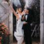 Joyful newlyweds celebrating their marriage with laughter and excitement, capturing authentic wedding day energy.