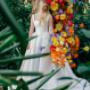 Elegant bride surrounded by vibrant florals and greenery, showcasing a timeless and cinematic wedding portrait in a natural setting.