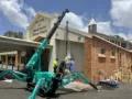 Mini crane lifting statue